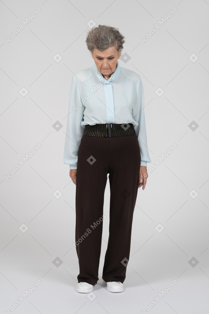 Old woman standing with head down