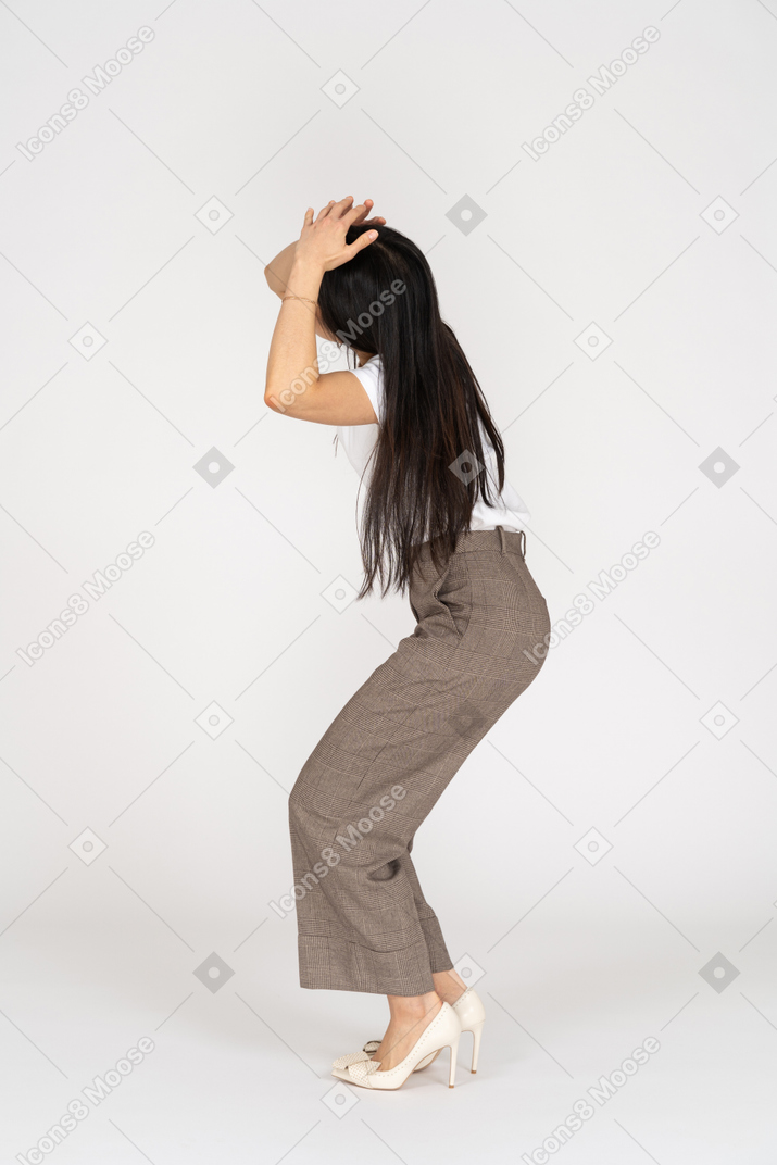 Side view of a scared young woman in breeches touching her head