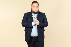 A plus-size man in a black costume with dollar bills in his hands