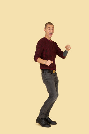 Three-quarter view of a young laughing man in red pullover