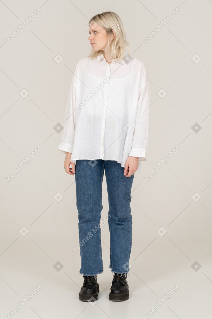 Front view of a cute blonde female in casual clothes looking aside