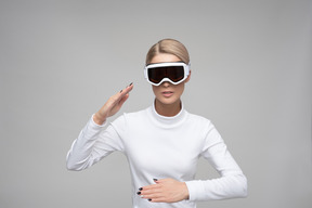 Young blonde woman in ski goggles performing a modern dance