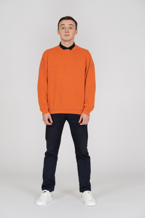 Young man in orange sweatshirt standing