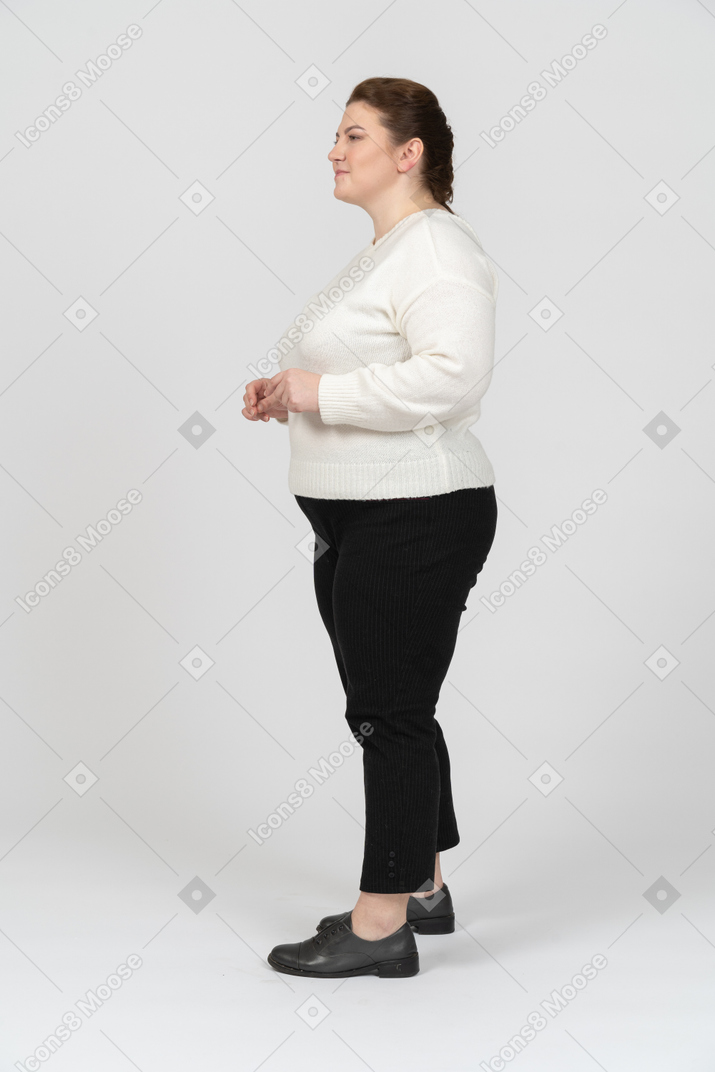 Plus size woman in casual clothes standing in profile