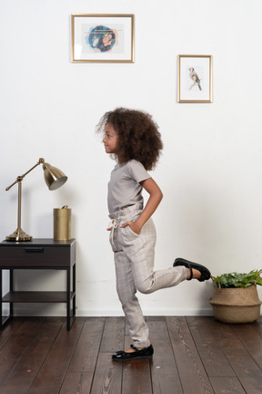 Good looking girl kid posing on the apartment background