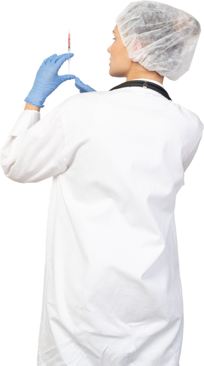 Vista posterior de una joven doctora sosteniendo una jeringa