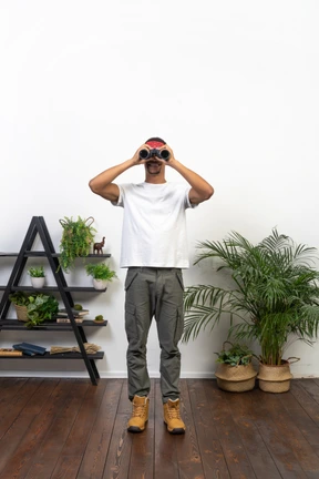 Good looking young man holding binoculars