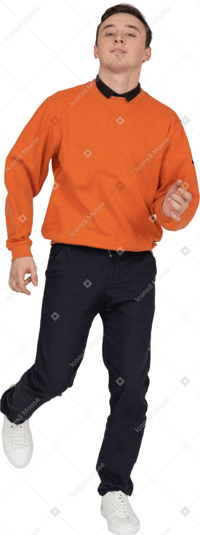 Jeune homme en sweat-shirt orange dansant