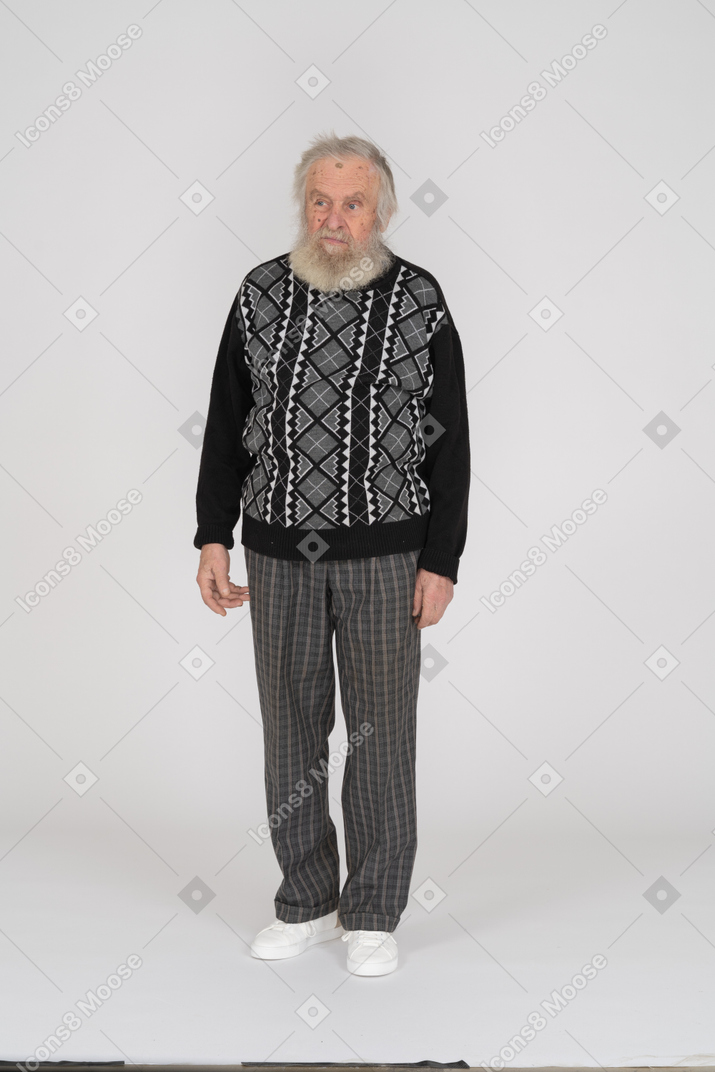 Displeased-looking elderly man standing with arms at side