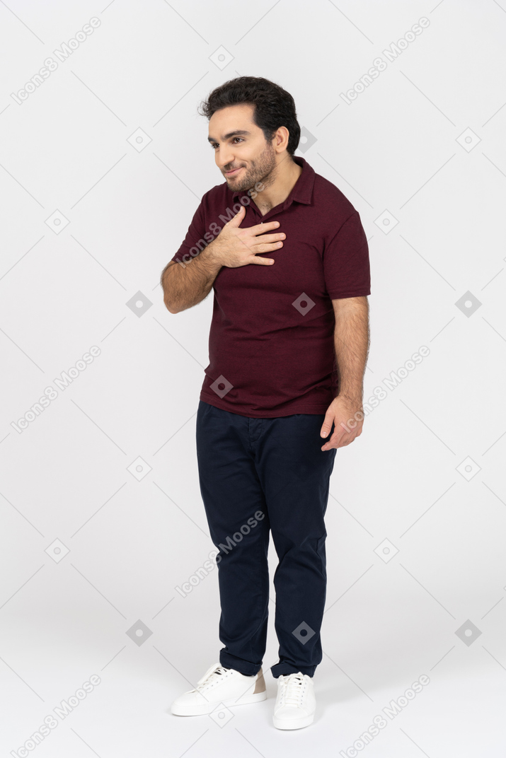 Homme en vêtements décontractés souriant avec la main sur la poitrine
