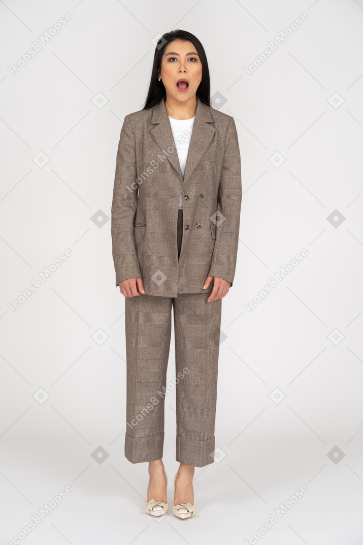 Front view of a young lady in brown business suit opening her mouth