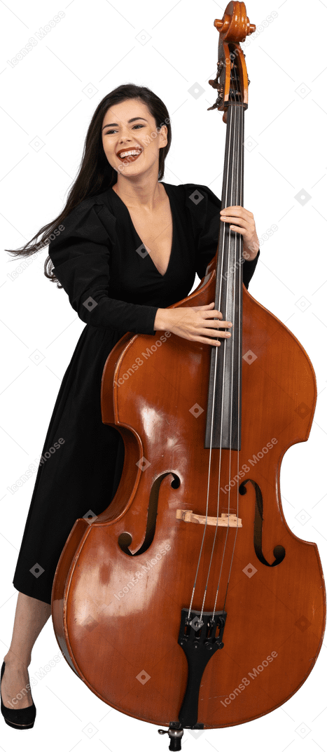 Vue de face d'une jeune femme souriante en robe noire jouant de la contrebasse