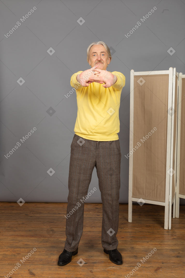 Front view of an old man stretching his arms
