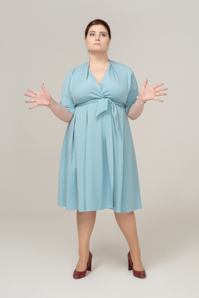Front view of a woman in blue dress standing with open arms