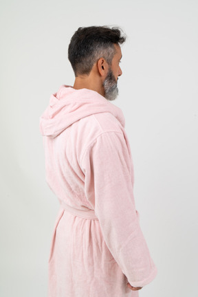 Man in pink robe standing back