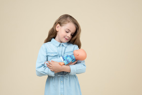 Linda niña sosteniendo una muñeca