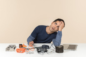 A young man in casual blue clothes working with computer details