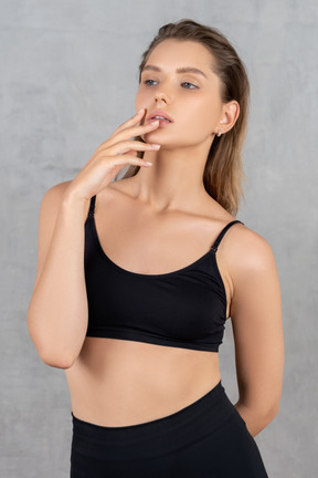 Attractive woman looking aside and holding fingers on her lips