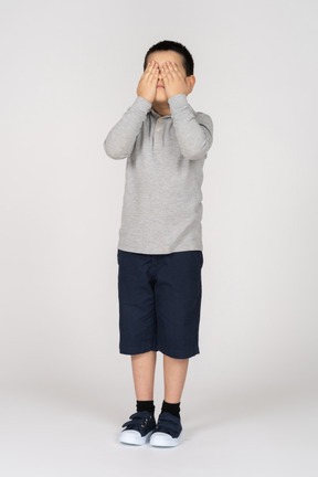 Boy covering eyes