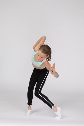 Front view of a teen girl bending knees and gesticulating