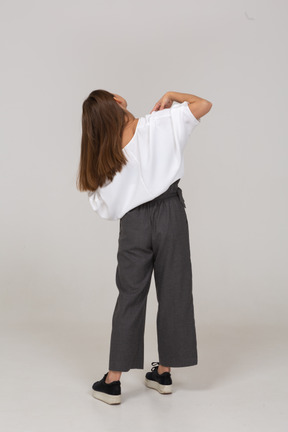 Back view of a young lady in office clothing touching her shoulders