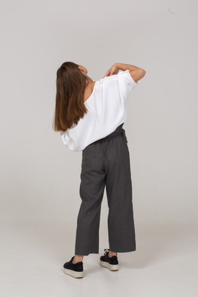 Vue arrière d'une jeune femme en vêtements de bureau touchant ses épaules