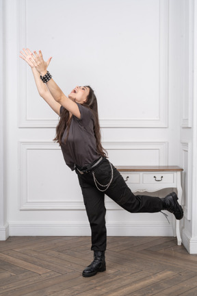 Three-quarter view of a female rocker outstretching her hands