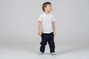 Little boy standing with his head turned