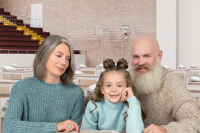 A man and a woman sitting at a table with a little girl