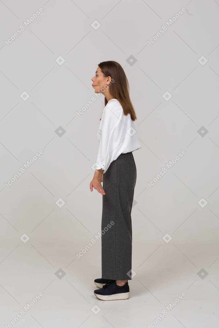 Side view of a young lady in office clothing pressing lips