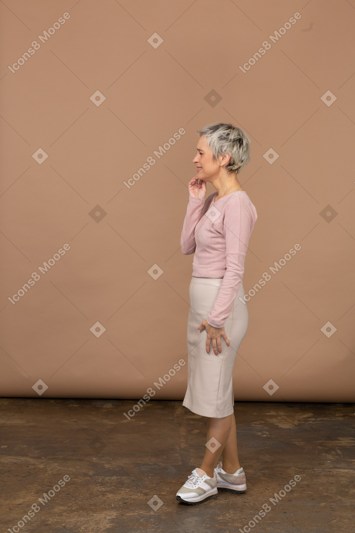 Mujer feliz en ropa casual tocando su barbilla