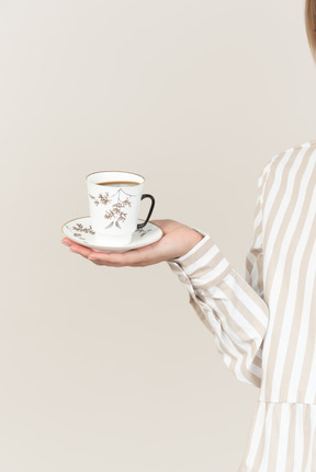 Female hand holding cup of tea