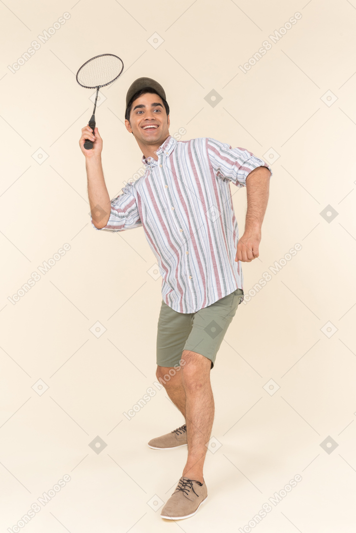 Rire jeune homme caucasien tenant une raquette de tennis