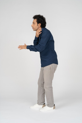 Side view of a man in casual clothes chocking himself