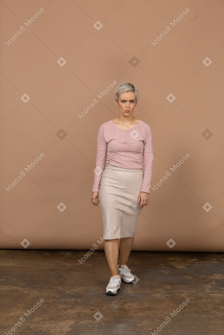 Vista frontal de uma mulher com roupas casuais caminhando para a frente