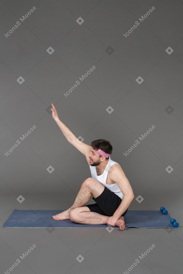 Sporty guy stretching his hand
