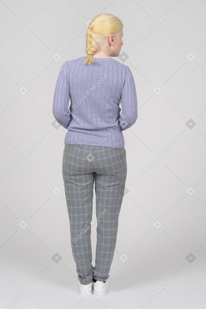 Vista traseira de uma mulher loira em roupas casuais, olhando para a direita