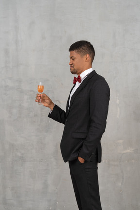 Disgusted young man looking at a champagne glass