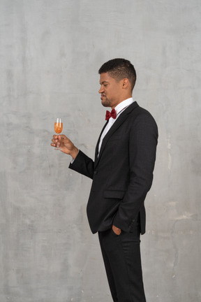 Jeune homme dégoûté regardant un verre de champagne