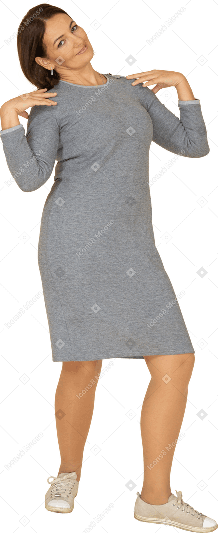 一个身着灰色连衣裙、双手放在肩上的女人的前视图
