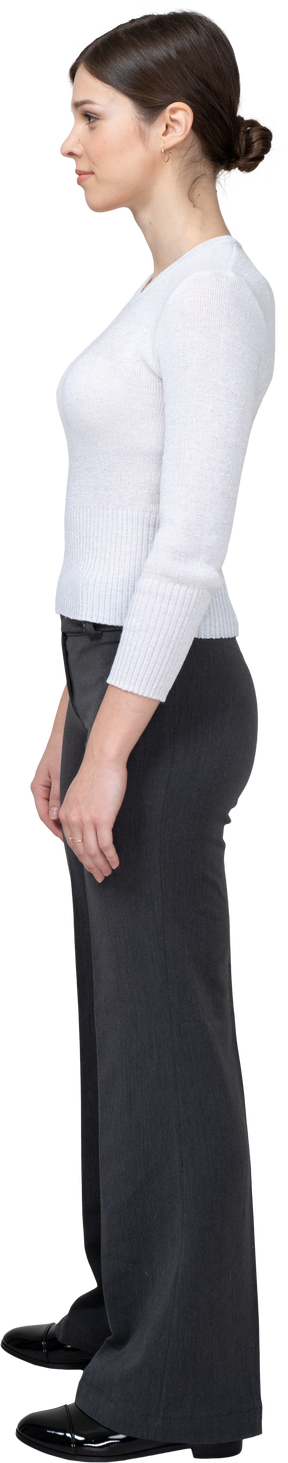 Side view of a young woman in office clothing standing still