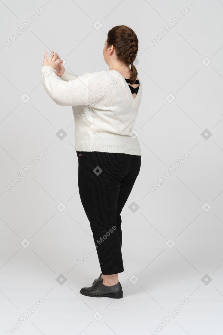 Plump woman in white sweater showing heart figure with his fingers