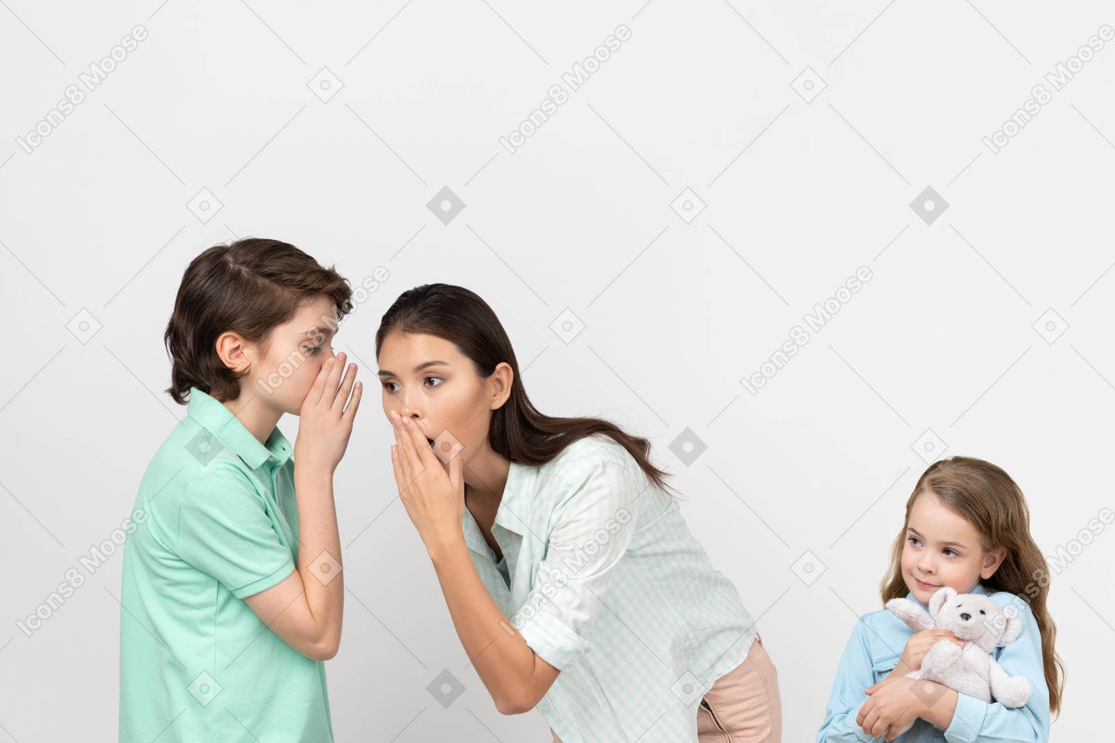 Boy whispering in mom's ear while his sister holding fluffy toy