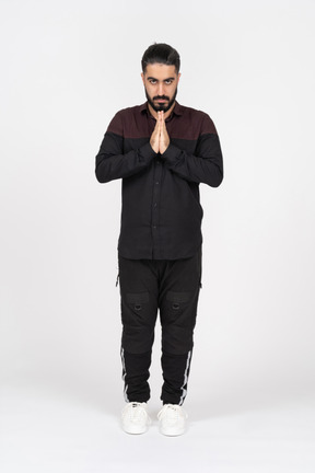 Young man praying with folded hands