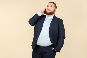 Ridendo giovane impiegato in sovrappeso parlando al telefono