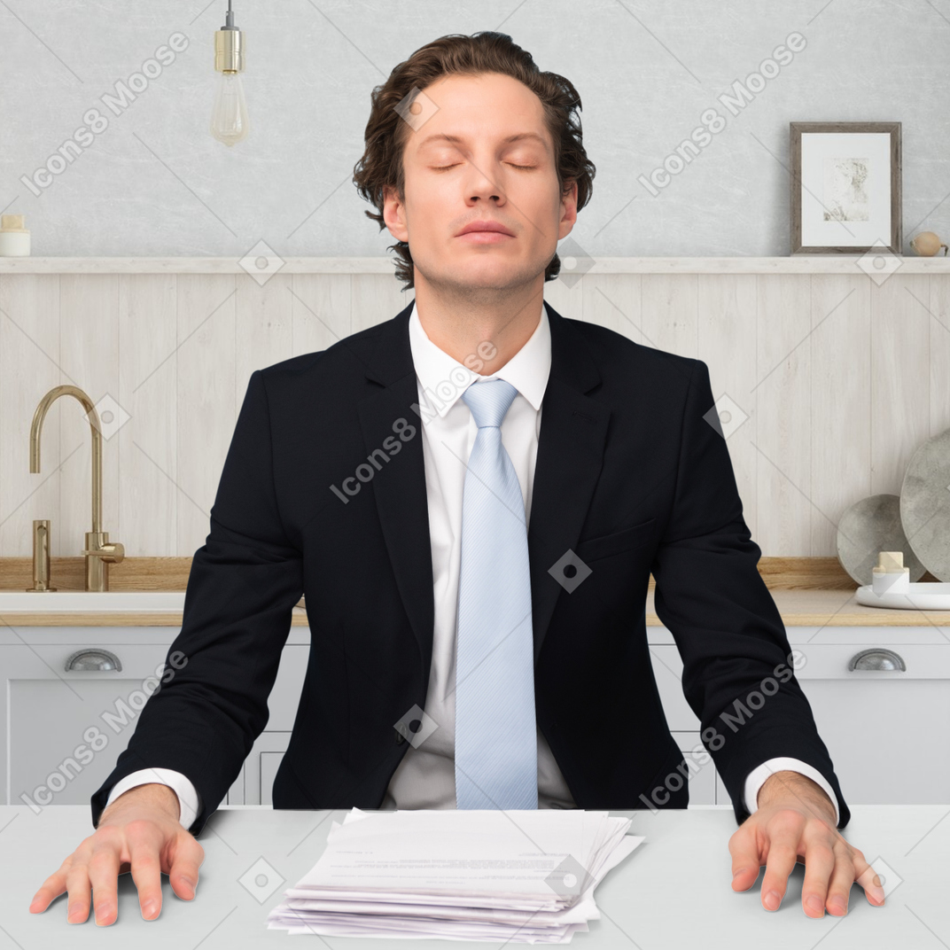 A man sitting at a desk with his eyes closed