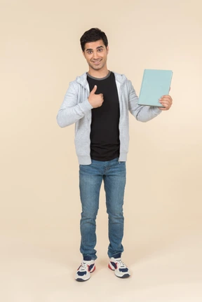 Young caucasian man pointing at book he's holding