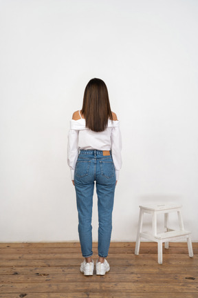 A woman standing in front of a white wall