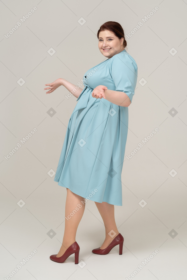 파란 드레스 몸짓에 행복 한 여자의 측면보기