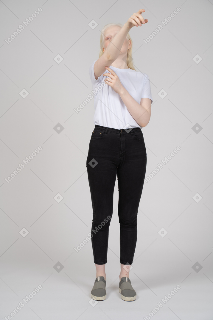 Mujer con ropa informal apuntando hacia arriba